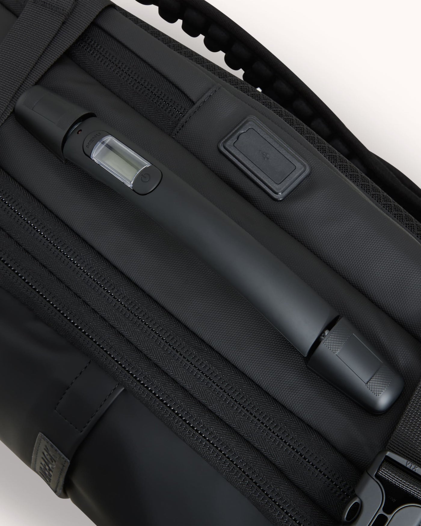 Mochila preta cheia sendo carregada pela alça superior reforçada